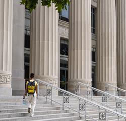 Student walking up the steps of the Angell Hall